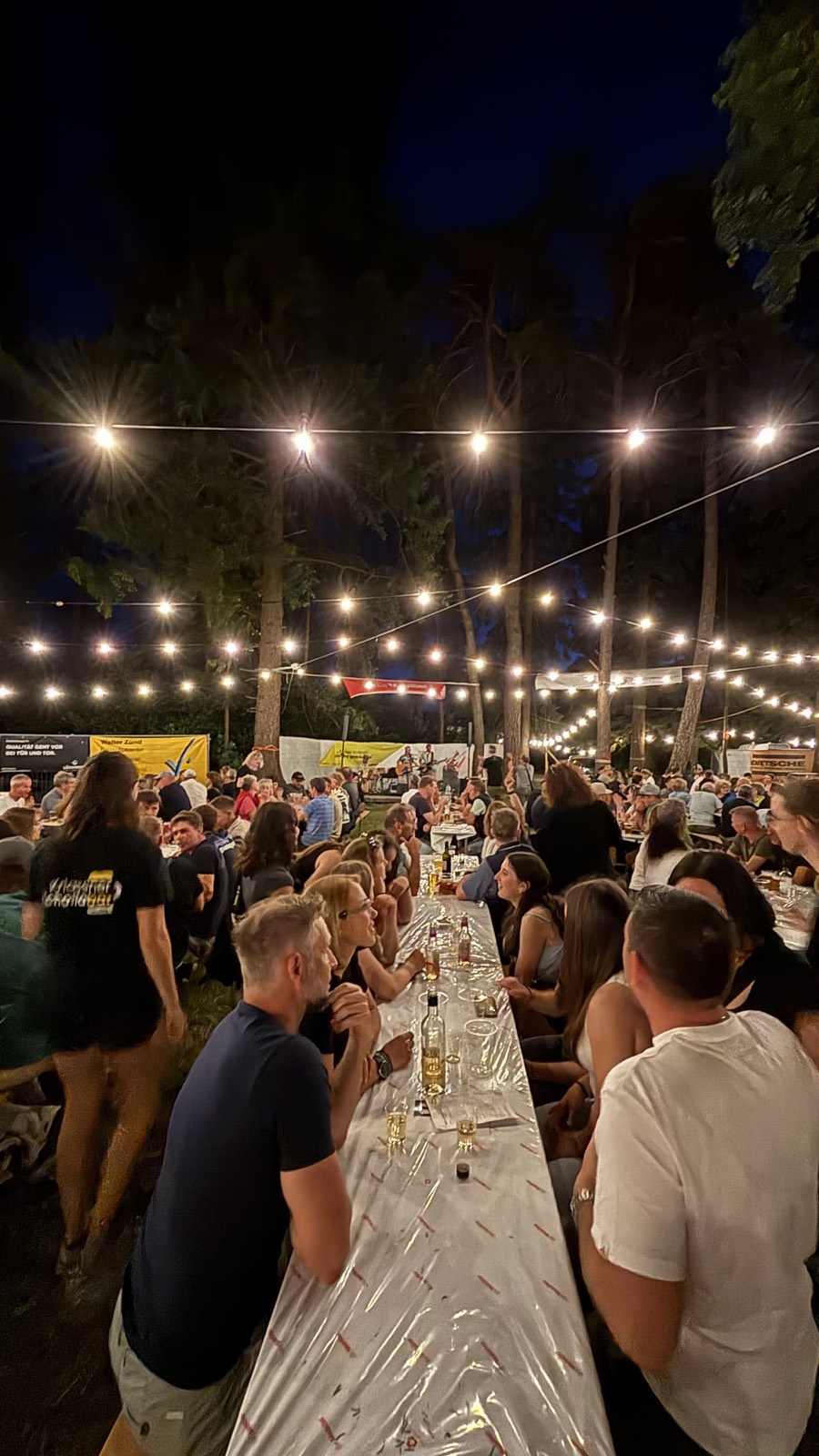 Lange Tafel unter der Lichterkette bei Nacht