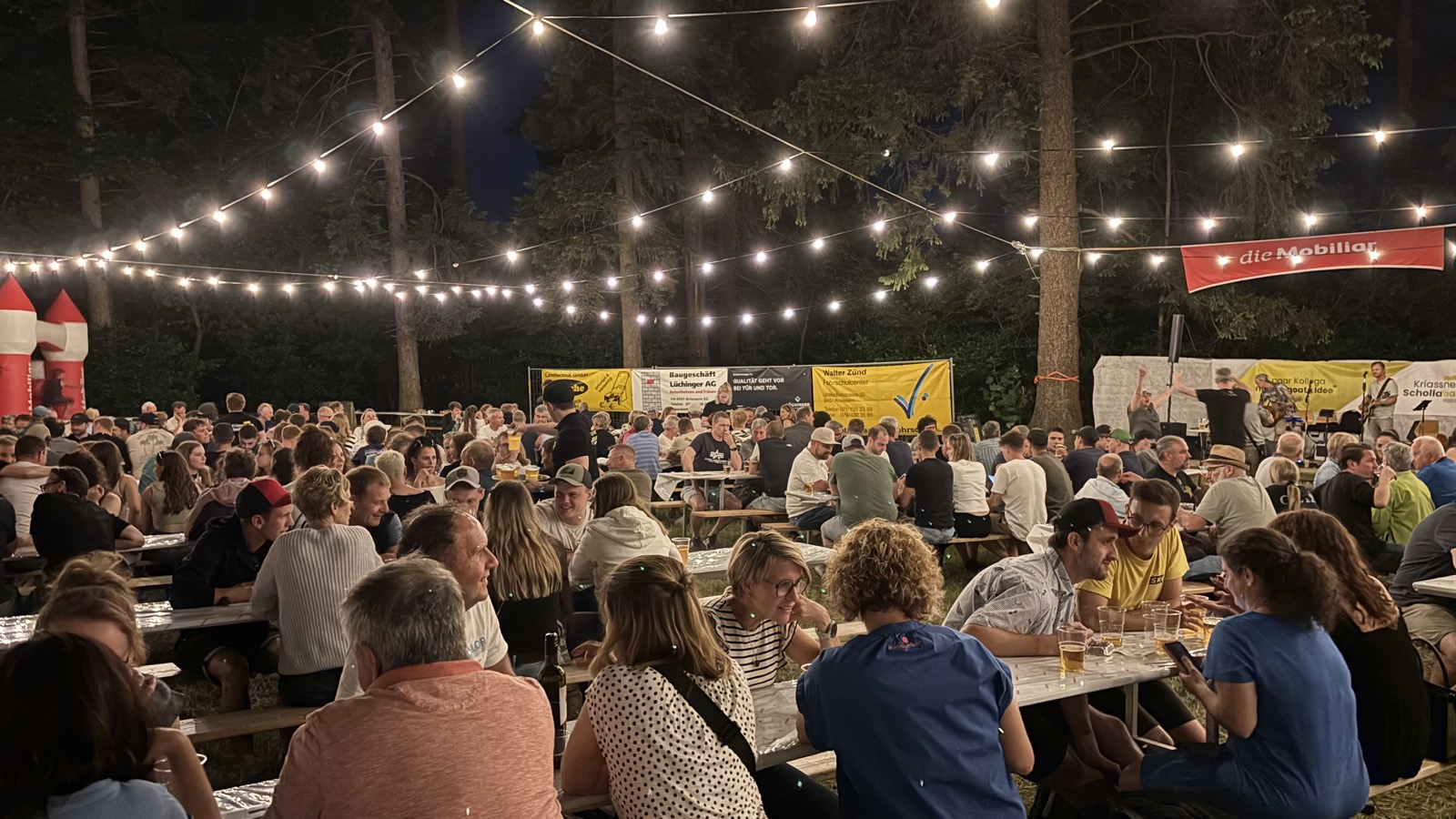 Volles Fest bei Nacht unter der Lichterkette